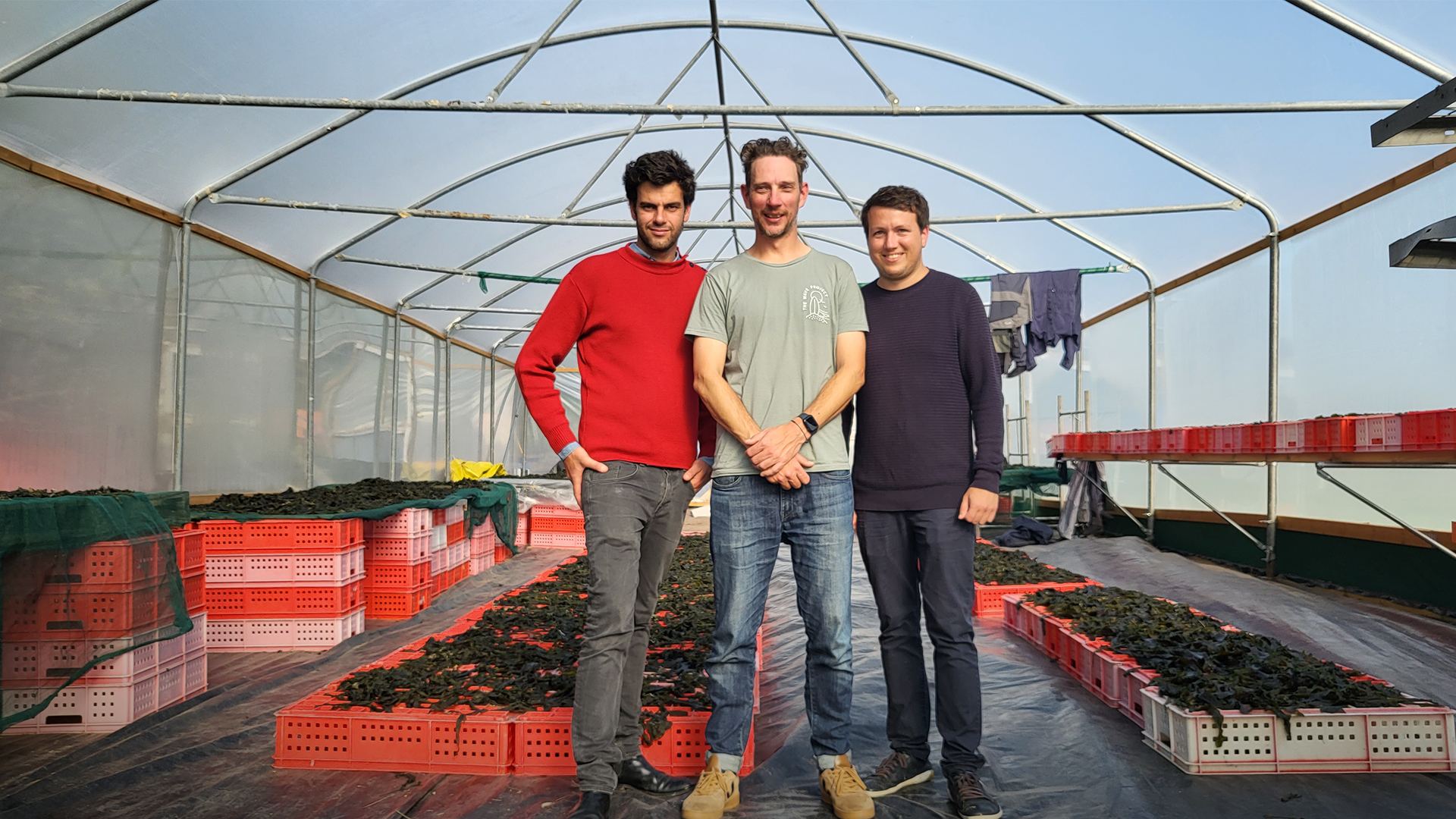 Members of the Notpla team standing inside a greenhouse.